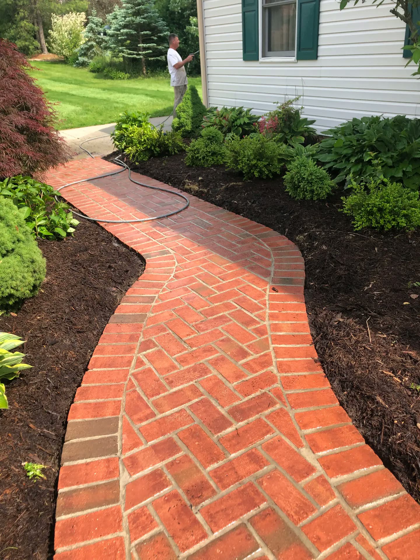 Long brick walkway cleaned with Randy working in the background