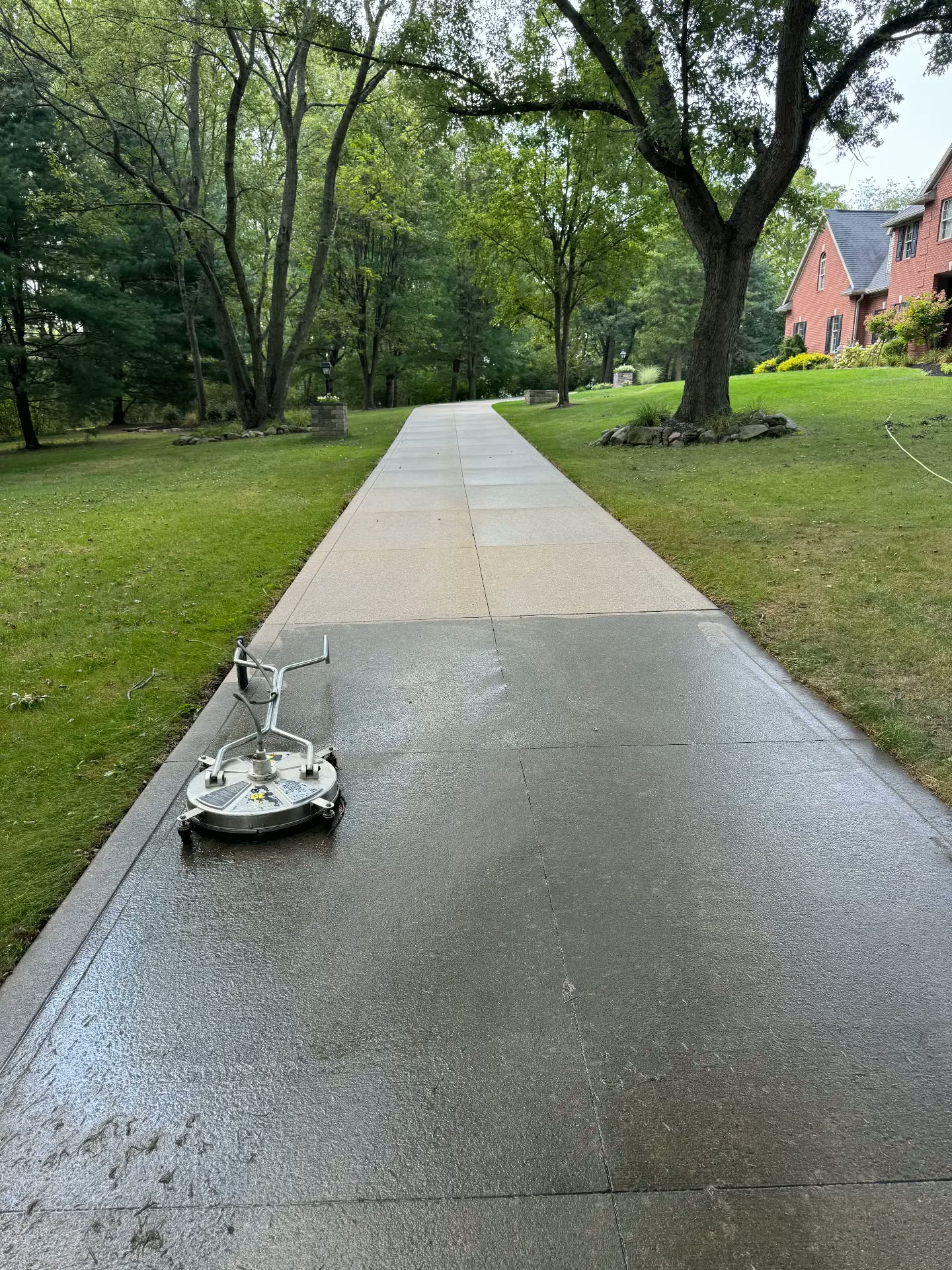 Dirty concrete driveway partway through surface cleaning